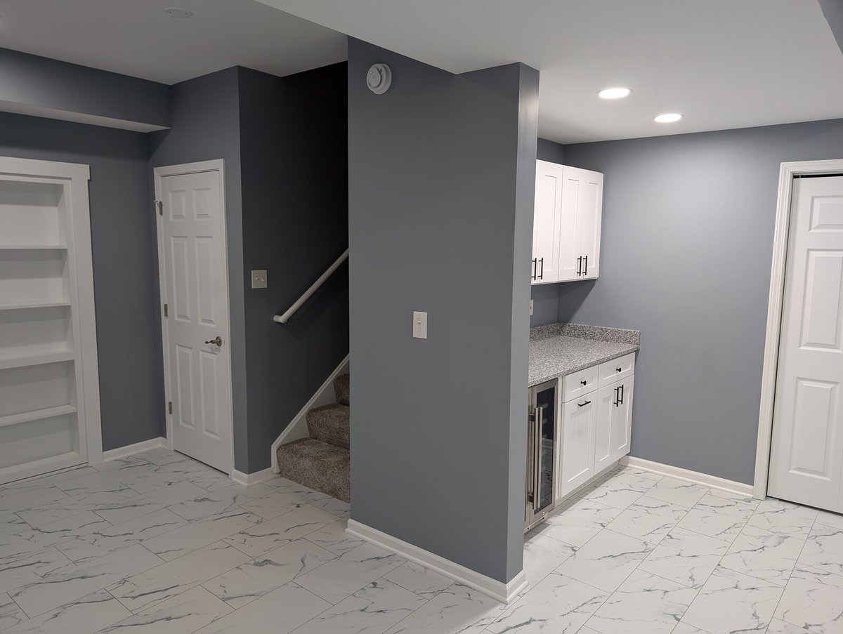 Basement remodel with a staircase and kitchenette area by Clear Contractors in Northwest Indiana