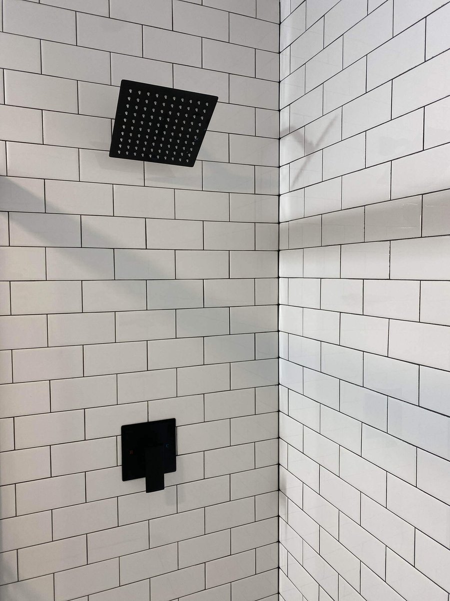 Close-up of a black square rainfall showerhead and white subway tiles in a Northwest Indiana bathroom remodel by Clear Contractors