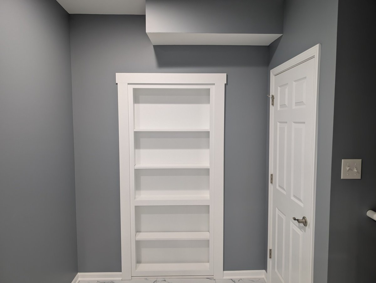 Custom-built bookshelf in a freshly painted basement during a Clear Contractors renovation project in Northwest Indiana