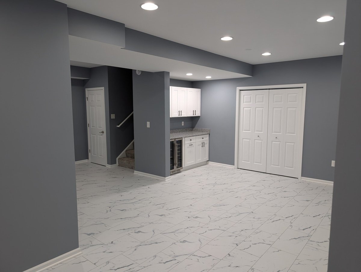 Modern basement with recessed lighting and a compact kitchenette by Clear Contractors in Northwest Indiana