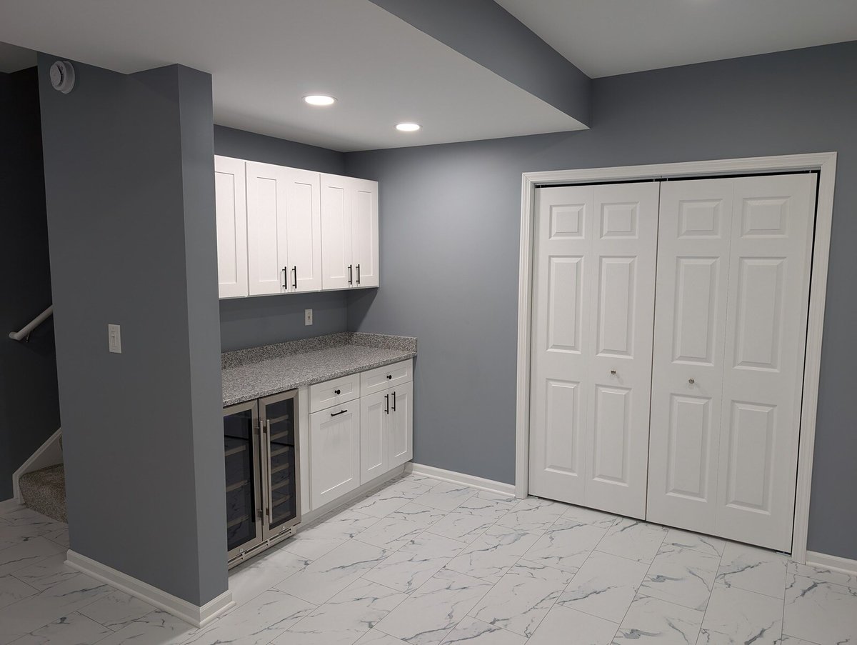 Stylish basement kitchenette with white cabinets and tile flooring by Clear Contractors in Northwest Indiana