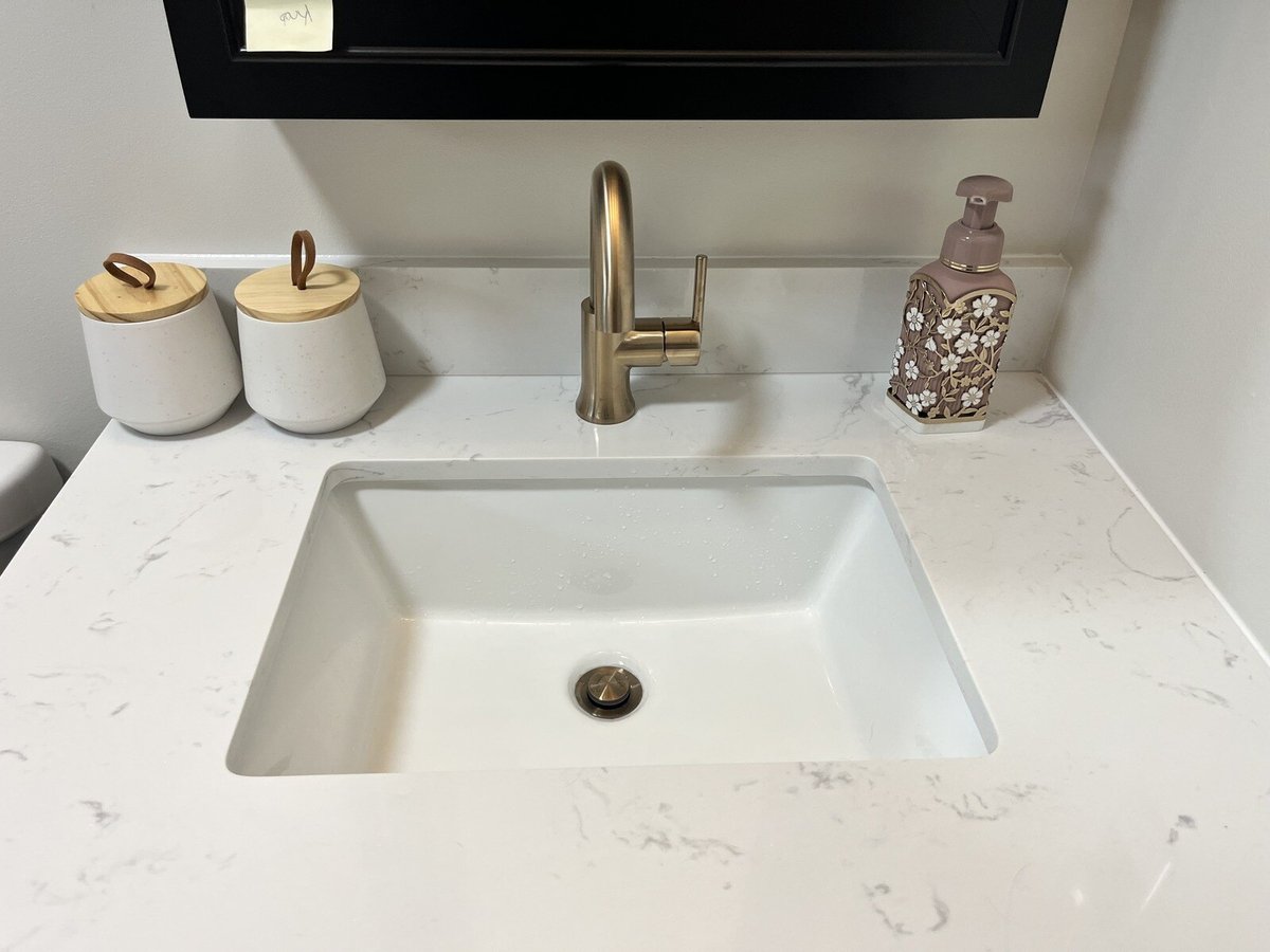 Bathroom remodel featuring a modern sink with gold hardware and ceramic containers by Clear Contractors in Northwest Indiana