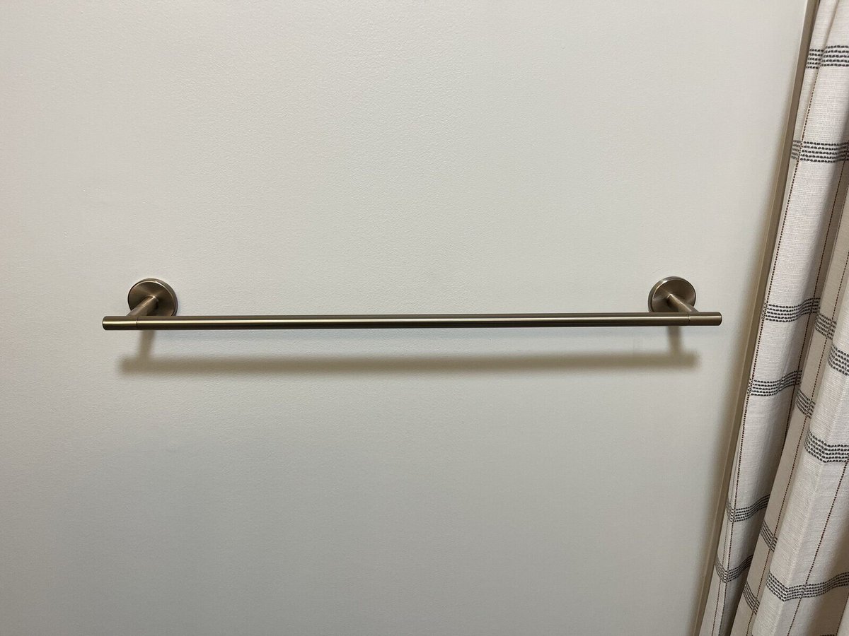 Wall-mounted gold towel rack in a modern bathroom remodeled by Clear Contractors in Northwest Indiana