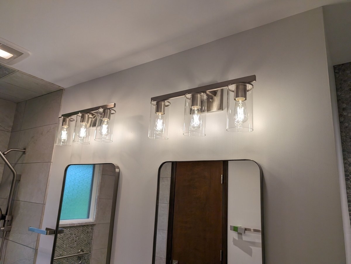 Elegant bathroom lighting fixtures with glass accents above dual mirrors, part of a remodel by Clear Contractors in Northwest Indiana