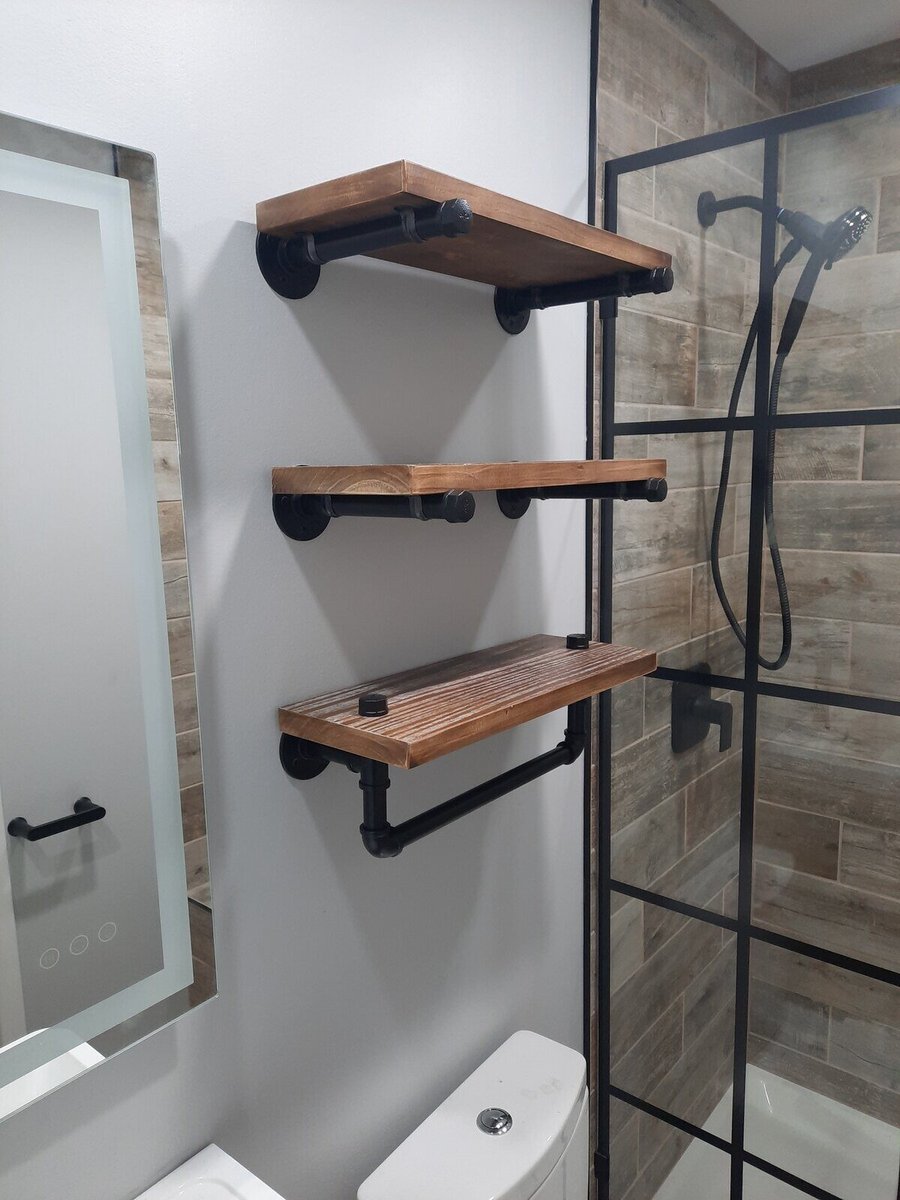 Industrial-style wooden shelves with black metal brackets in a remodeled Northwest Indiana bathroom by Clear Contractors