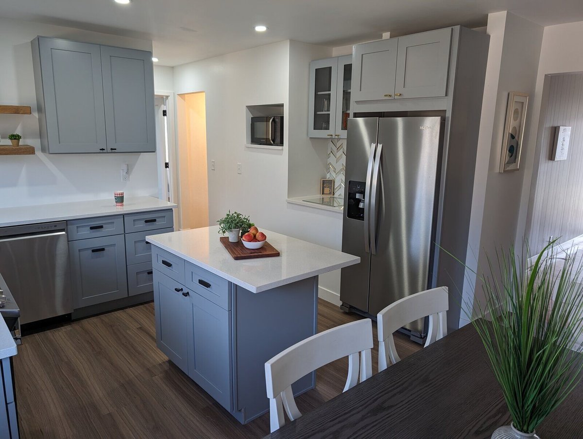 Modern kitchen renovation with gray cabinetry, island, and stainless steel appliances by Clear Contractors in Northwest Indiana