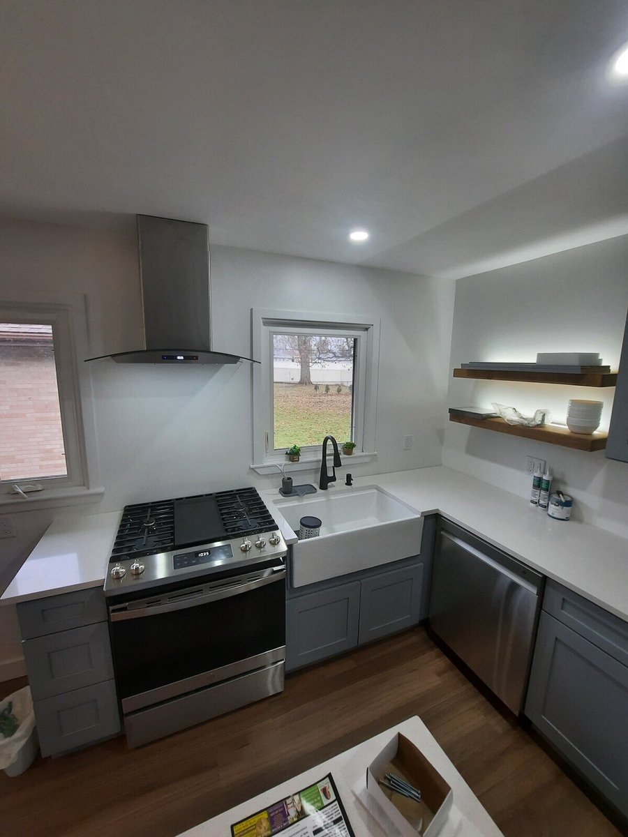 Stainless steel stove and farmhouse sink in a modern kitchen remodel by Clear Contractors in Northwest Indiana